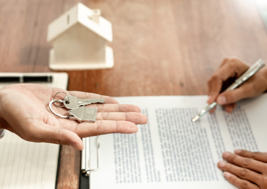 Inmobiliario sosteniendo llaves de vivienda nueva de comprador