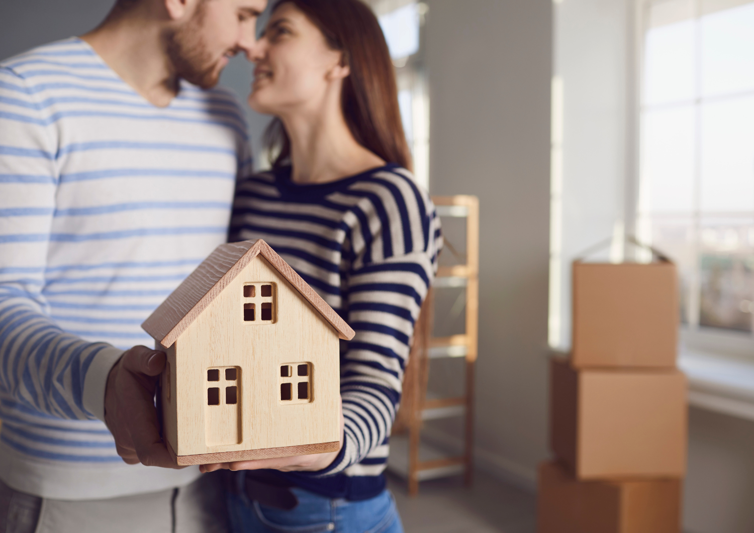 Pareja enamorada sosteniendo su nuevo hogar