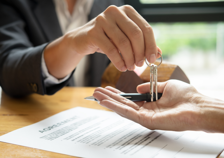 Agente inmobiliario entregando llaves de domicilio a comprador