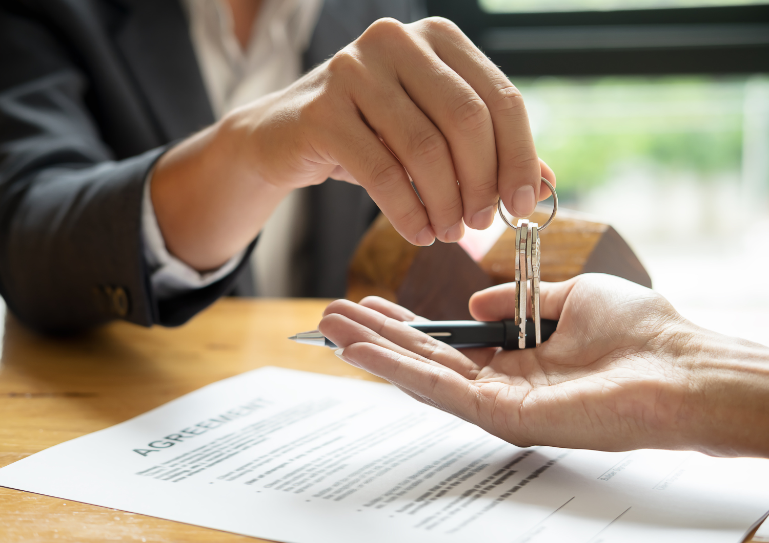 Agente inmobiliario entregando llaves de domicilio a comprador